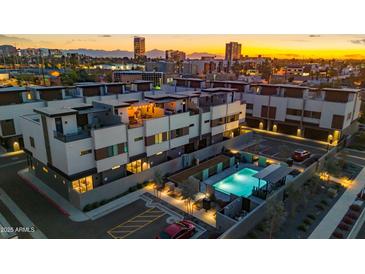 Modern townhome community showcasing a rooftop deck, sparkling pool, and city views during sunset at 377 E Windsor Ave # 16, Phoenix, AZ 85004