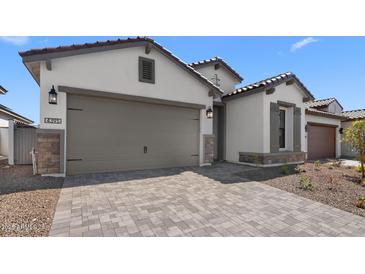 Charming single Gathering home featuring a spacious garage and tasteful desert landscaping at 4395 N 203Rd Ave, Buckeye, AZ 85396