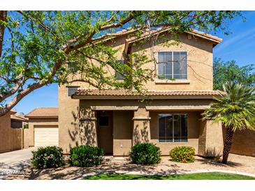 Inviting two-story home featuring desert landscaping, neutral colors, and an attached two-car garage at 560 E Rainbow Dr, Chandler, AZ 85249