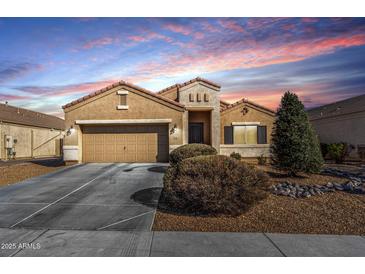 Inviting single-story home showcasing a two-car garage, desert landscaping, and picturesque sunset at 9450 W Georgia Ave, Glendale, AZ 85305