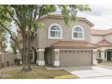 Charming two-story home featuring a well-manicured lawn, neutral colored exterior, and a two car garage at 1249 W Seascape Dr, Gilbert, AZ 85233