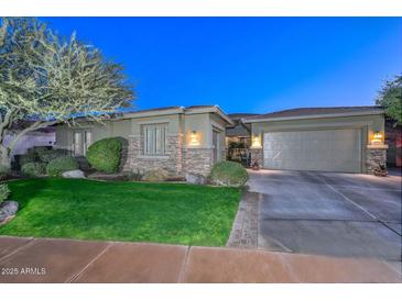 Charming single-story home with a well-manicured lawn, stone accents, and an attached two-car garage at 12859 W Calle De Baca --, Peoria, AZ 85383