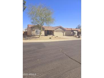 Charming single-story home featuring desert landscaping, a tile roof, and an attached two-car garage at 13636 W Antelope Dr, Sun City West, AZ 85375