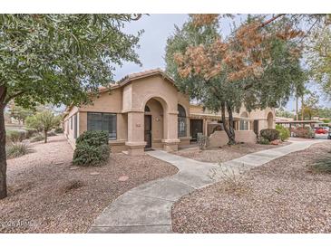 Charming single-story home featuring a stucco facade, arched entryway, and well-maintained landscaping at 14300 W Bell Rd # 307, Surprise, AZ 85374