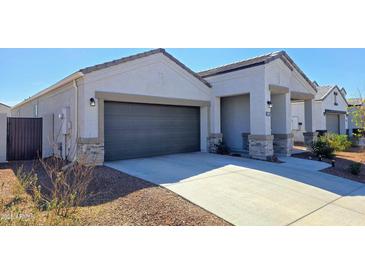 Charming single-Gathering home featuring a two-car garage and covered entrance with desert landscaping at 18809 W Wilson St, Buckeye, AZ 85326