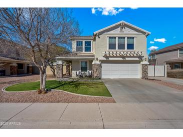 Charming two-story home featuring stone accents, a well-manicured lawn, and a welcoming front porch at 1928 E 39Th Ave, Apache Junction, AZ 85119