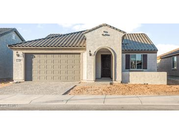 Charming single-story home with a two-car garage, arched entry, and tile roof at 26982 W Lone Cactus Dr, Buckeye, AZ 85396