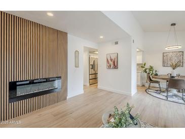 Bright living room featuring a fireplace with wood paneling and neutral decor, creating a warm and inviting atmosphere at 3102 E Clarendon Ave # 210, Phoenix, AZ 85016