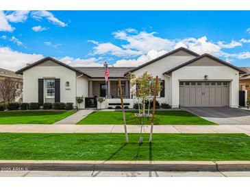 Beautiful single-story home featuring a lush green lawn, charming landscaping, and a convenient two-car garage at 3483 E Bloomfield Pkwy, Gilbert, AZ 85296