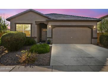 Charming single-story home featuring a neutral color palette, two-car garage, and desert landscaping at 393 S Soledad Ln, Casa Grande, AZ 85194