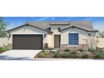 Inviting single-story home with neutral stucco, brick accents, desert landscaping, and an attached two-car garage at 4924 W Capistrano Ave, Laveen, AZ 85339