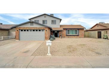 Charming two-story home featuring a well-manicured front yard and a classic brick facade at 5228 W Ironwood Dr, Glendale, AZ 85302