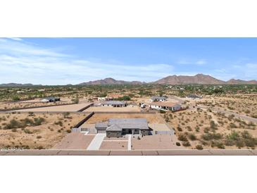 Expansive aerial view of a desert property featuring a modern home with mountain backdrop at 12204 W Blackhawk Rd, Casa Grande, AZ 85194