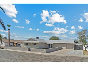 Charming single-story home with a low block wall, mature trees, and a driveway at 13202 N 22Nd Ave, Phoenix, AZ 85029