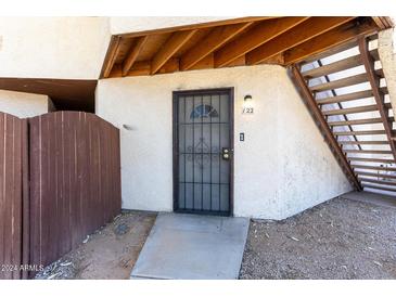 Welcoming front entrance with security door, textured wall and wooden stairs to the right at 16402 N 31 St # 122, Phoenix, AZ 85032