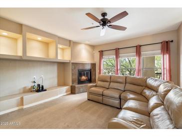 Inviting living room with fireplace, built-in shelving, and a comfortable sectional sofa at 16800 E El Lago Blvd # 2062, Fountain Hills, AZ 85268