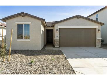 Charming single-story home featuring a two-car garage, desert landscaping, and a welcoming front entrance at 17165 W Corrine Dr, Surprise, AZ 85388