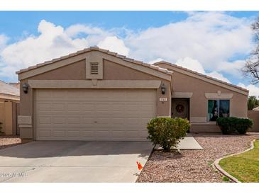 Inviting single-story home featuring a well-maintained front yard with a two car garage at 1753 E Pinto Dr, Gilbert, AZ 85296