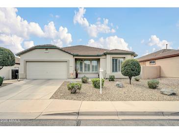 Charming single story home with desert landscaping, concrete driveway, and a two car garage at 18033 W Carmen Dr, Surprise, AZ 85388