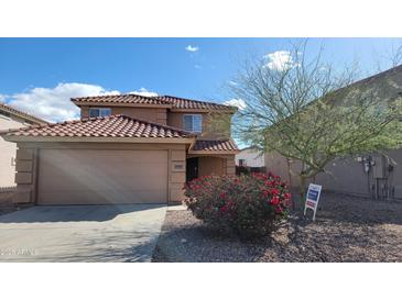 Inviting two-story home with a well-maintained front yard and charming desert landscaping in a sunny neighborhood at 22067 W Cantilever St, Buckeye, AZ 85326