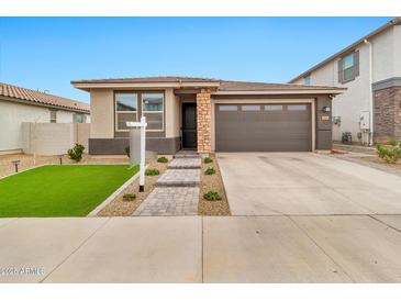 Charming single-story home with a well-manicured lawn and neutral colored exterior at 25583 S 224Th Pl, Queen Creek, AZ 85142