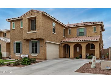 Inviting two-story home featuring a covered entry, attached garage and manicured landscaping at 26868 N 104Th Ln, Peoria, AZ 85383