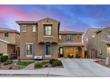 Charming two-story home with a neutral stucco exterior, decorative shutters, and a well-manicured front yard at 26868 N 104Th Ln, Peoria, AZ 85383