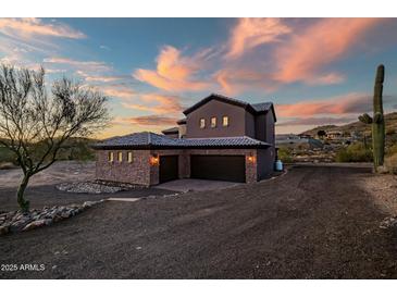 Beautiful two-story home featuring a three-car garage and desert landscaping at sunset at 36430 N 34Th Ave, Phoenix, AZ 85086