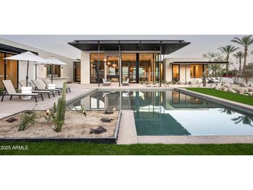 Stunning backyard oasis with modern pool, desert landscaping, and covered patio perfect for relaxation and entertaining at 5287 N Invergordon Rd, Paradise Valley, AZ 85253