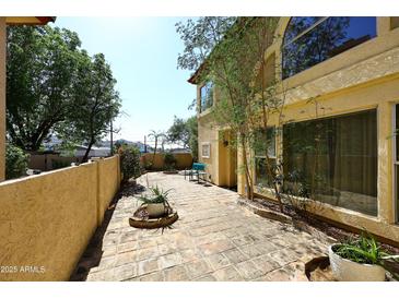 Relaxing outdoor patio with brick flooring and a stucco wall, perfect for enjoying the Arizona sunshine at 10218 N 12Th Pl # 2, Phoenix, AZ 85020