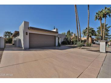 Lovely single-story home featuring desert landscaping, wide driveway, and an attached two-car garage at 10421 E Silvertree Dr, Sun Lakes, AZ 85248