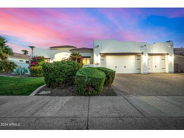 Stunning white home with a 3-car garage and beautiful desert landscaping at dusk at 11343 E Appaloosa Pl, Scottsdale, AZ 85259