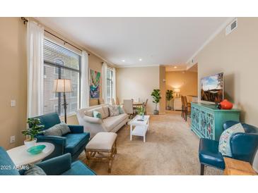 Bright living room featuring neutral walls, plush seating, and a view into an adjacent dining and bar area at 11640 N Tatum Blvd # 2063, Phoenix, AZ 85028