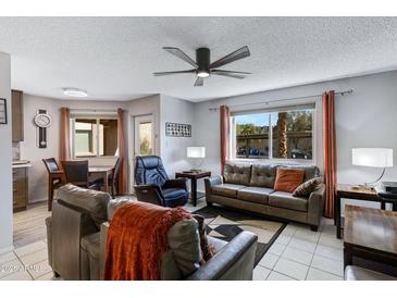 Inviting living room features neutral colors, comfortable seating, tile flooring, and a ceiling fan at 145 N 74Th St # 121, Mesa, AZ 85207