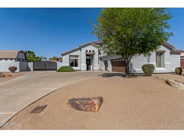 Charming single-story home featuring a spacious driveway and a well-maintained landscape with mature trees at 18468 N 63Rd Dr, Glendale, AZ 85308