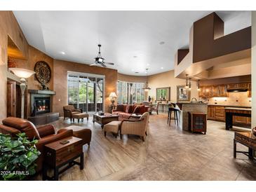 Spacious living room featuring a fireplace, comfortable seating, and abundant natural light at 18944 E Amethyst Dr, Rio Verde, AZ 85263