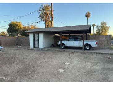 A detached garage with a carport is featured in the yard of this property at 2045 W Colter St, Phoenix, AZ 85015