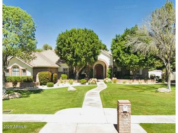 Charming single-story home with a lush green lawn, mature trees, and a curved walkway leading to the front door at 2170 E Caroline Ln, Tempe, AZ 85284