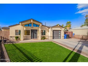 Charming home with a well-maintained lawn, modern garage door, and covered front entrance at 2638 E Edgemont Ave, Phoenix, AZ 85008