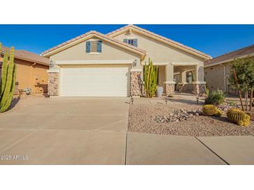 Inviting home with neutral stucco, river rock accents, desert landscaping and a 2 car garage at 30153 N Gecko Trl, San Tan Valley, AZ 85143