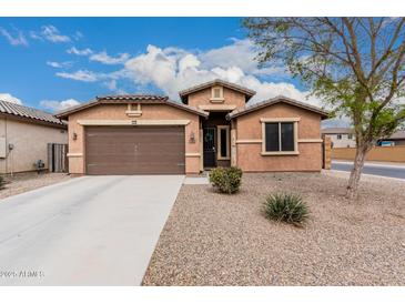 Charming single-story home with a two-car garage and low-maintenance desert landscaping at 38062 W San Capistrano Ave, Maricopa, AZ 85138