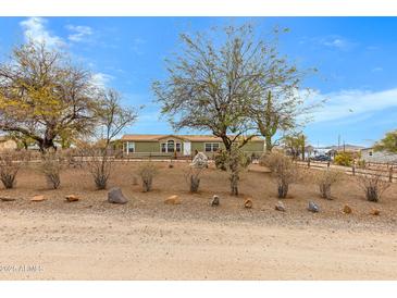 Ranch-style home features a desert-style landscaped front yard with mature trees and native vegetation at 38413 N 16Th St, Phoenix, AZ 85086