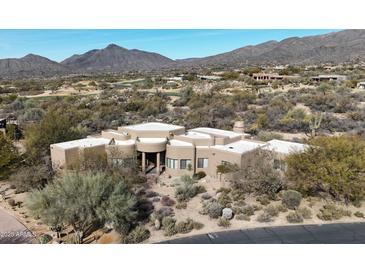 Expansive desert home boasting a flat roof, stucco exterior, and views of green golf course and majestic mountains at 40262 N 107Th Pl, Scottsdale, AZ 85262