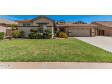 Charming home featuring a lush green lawn and manicured landscaping, creating a welcoming curb appeal at 4109 E Del Rio St, Gilbert, AZ 85295