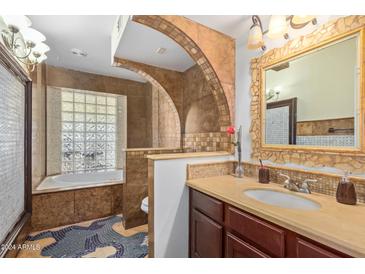 Unique bathroom design with a glass block shower, archway, and mosaic tile flooring at 4747 W Sunnyside Ave, Glendale, AZ 85304