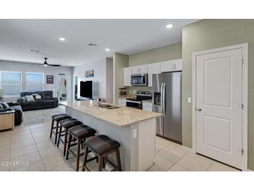 Modern kitchen featuring stainless steel appliances, granite countertops, and an island with seating at 47737 W Coe St, Maricopa, AZ 85139