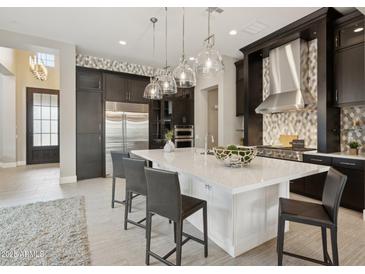 A gourmet kitchen with stainless steel appliances, a large island, and stylish pendant lighting at 5411 E Duane Ln, Cave Creek, AZ 85331