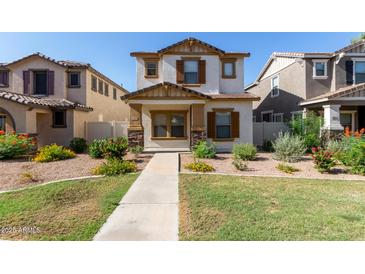 Charming two-story home featuring a stucco exterior, brown shutters, and a well-maintained landscaped front yard at 5828 E Hoover Ave, Mesa, AZ 85206