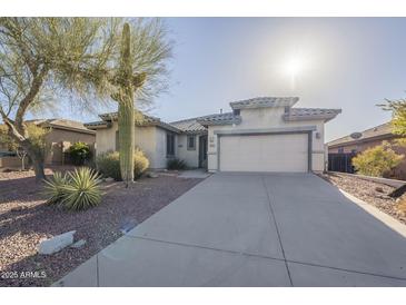 Charming single-story home featuring a well-maintained front yard with desert landscaping and a two-car garage at 4243 S Hackberry Trl, Gold Canyon, AZ 85118