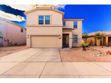 Two-story home showcasing a well-kept yard, two-car garage, and desert-friendly landscaping at 44165 W Kramer Ln, Maricopa, AZ 85138